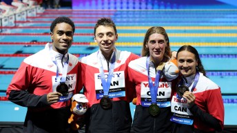 Team Canada swimmers smile with their bronze medal