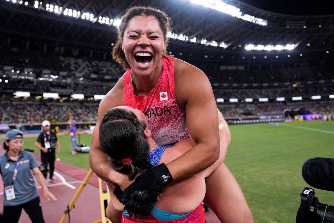 Camryn Rogers leaps in the arms of an American competitor
