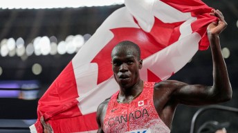 Marco Arop holds a Canadian flag behind his back