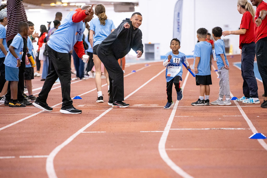 Andre De Grasse encourages a child while they sprint