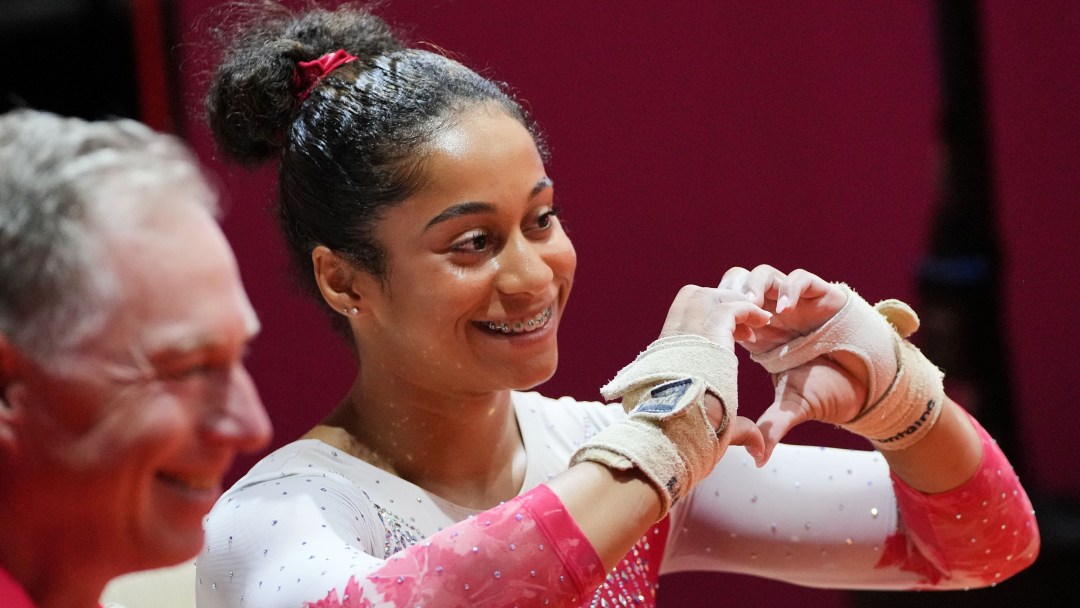 In a red and white leotard, Lia-Monica Fontaine forms a heart with her hands