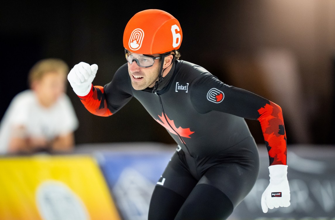 Dressed in black skin suit and red helmet the skater pumps his first in celebration