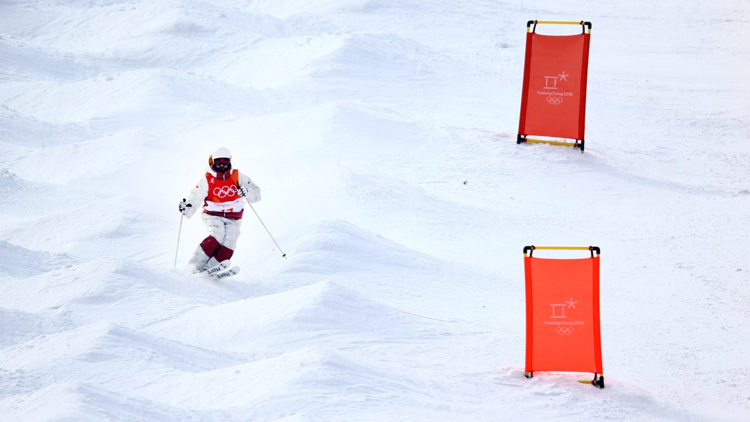A moguls skier goes through the course of bumps