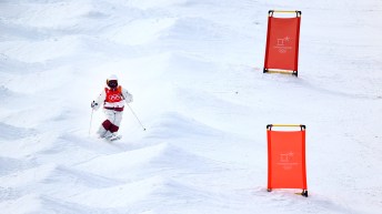 A moguls skier goes through the course of bumps