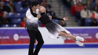 Marjorie Lajoie in black dress is lifted off the ice by Zachary Lagha in black pants and white top