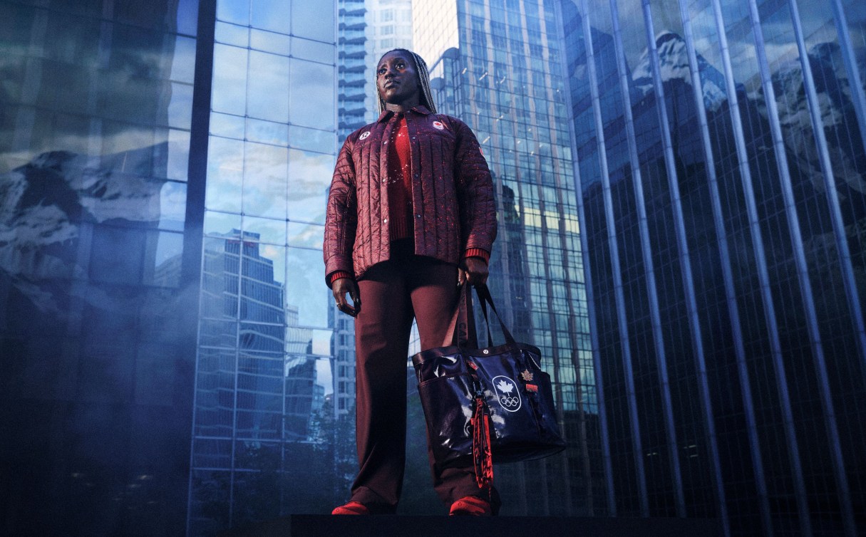 Cynthia Appiah stands with tall glass buildings behind her in a burgundy coloured outfit