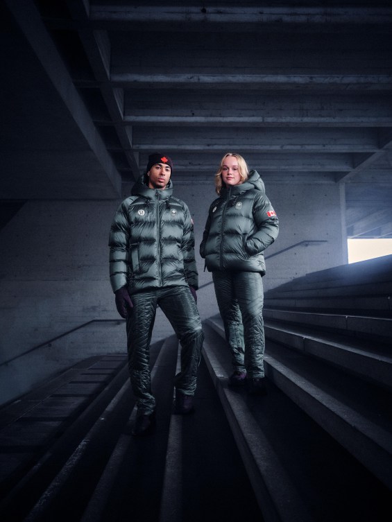 William Dandjinou and Emma Maltais pose on steps in greenish blue jacket and pants