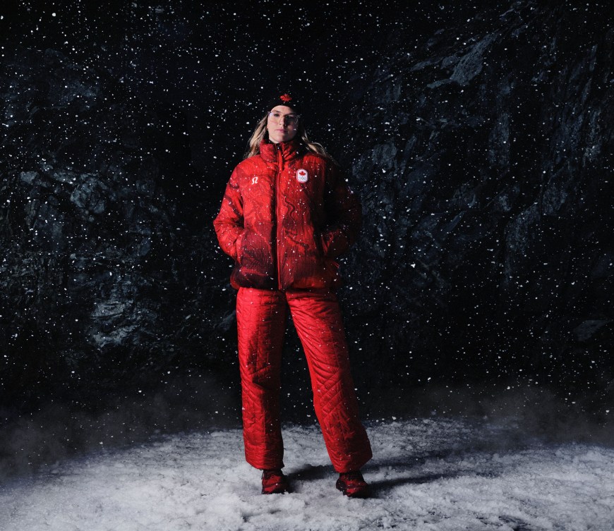 Cassie Sharpe stands in fallin snow dressed in red jacket and pants