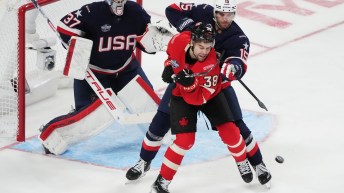 PLayer in red battles player in navy blue in front of net