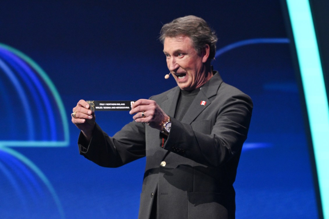 Wayne Gretzky holds up a slip of paper at the 2026 FIFA World Cup draw