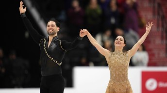 Deanna Stellato-Dudek in a gold dress prepares to bow alongside Maxime Deschamps in a black shirt and pants