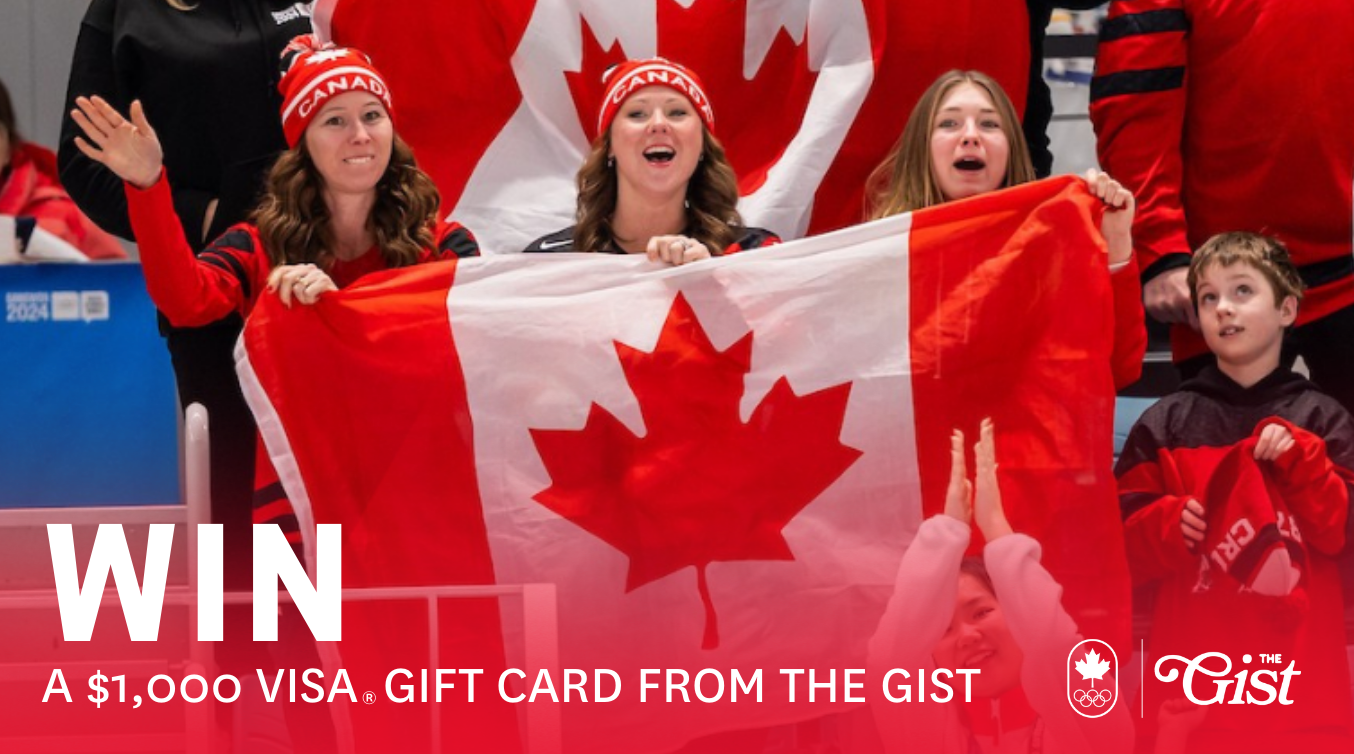 Three fans holding a Canadian flag in a crowd.