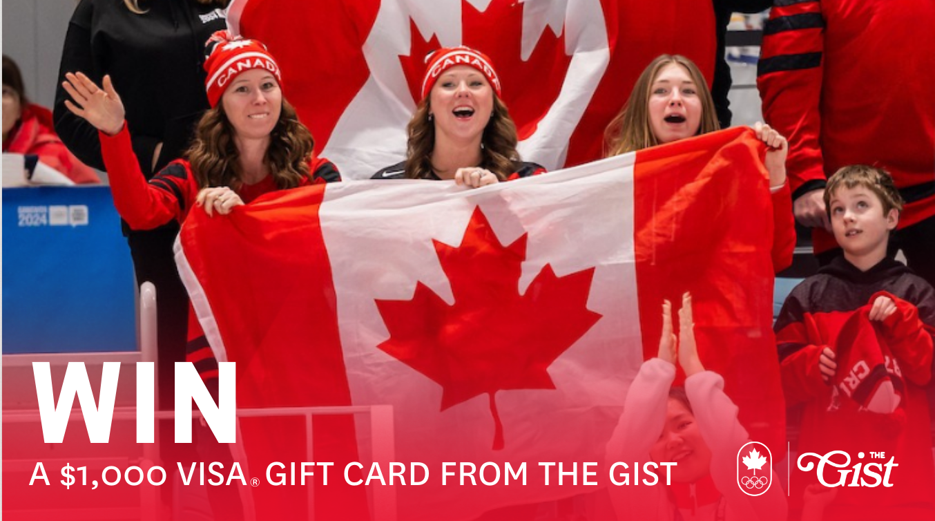 Three fans holding a Canadian flag in a crowd.
