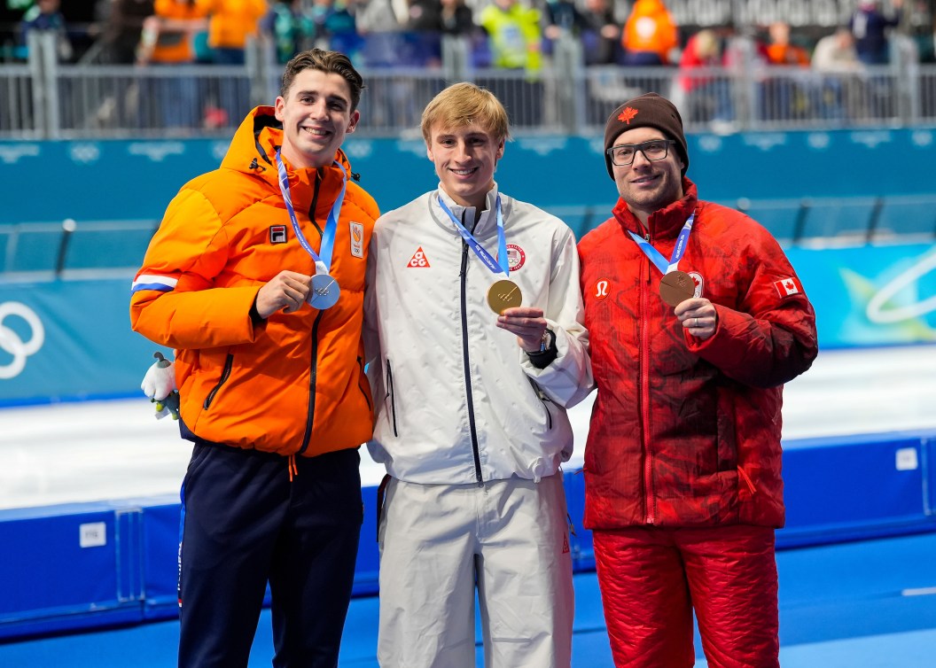 Jenning de Boo, Jordan Stolz and Laurent Dubreuil with their Olympic medals around their necks.