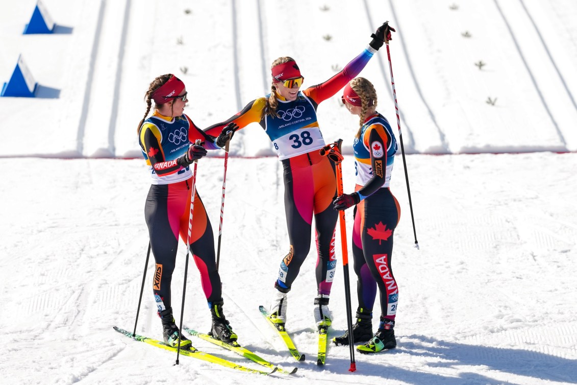 Team Canada reacts after crossing the finish line in the cross country skiing