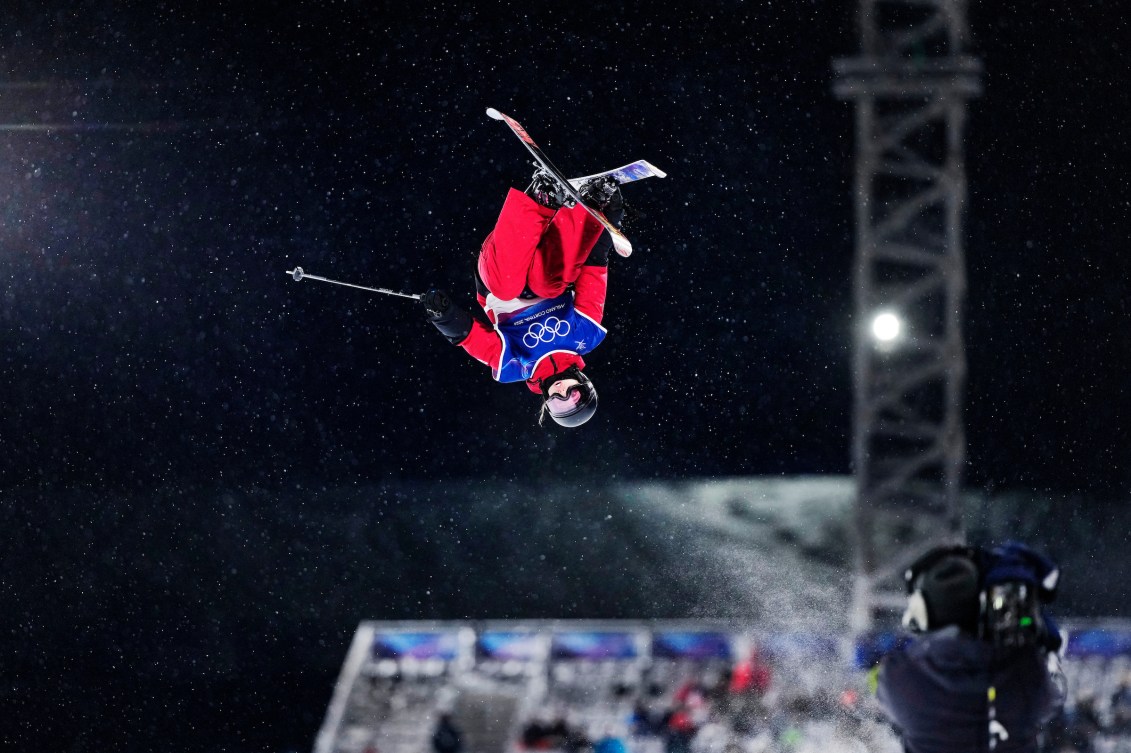 Amy Fraser flipping through dark sky during competition.