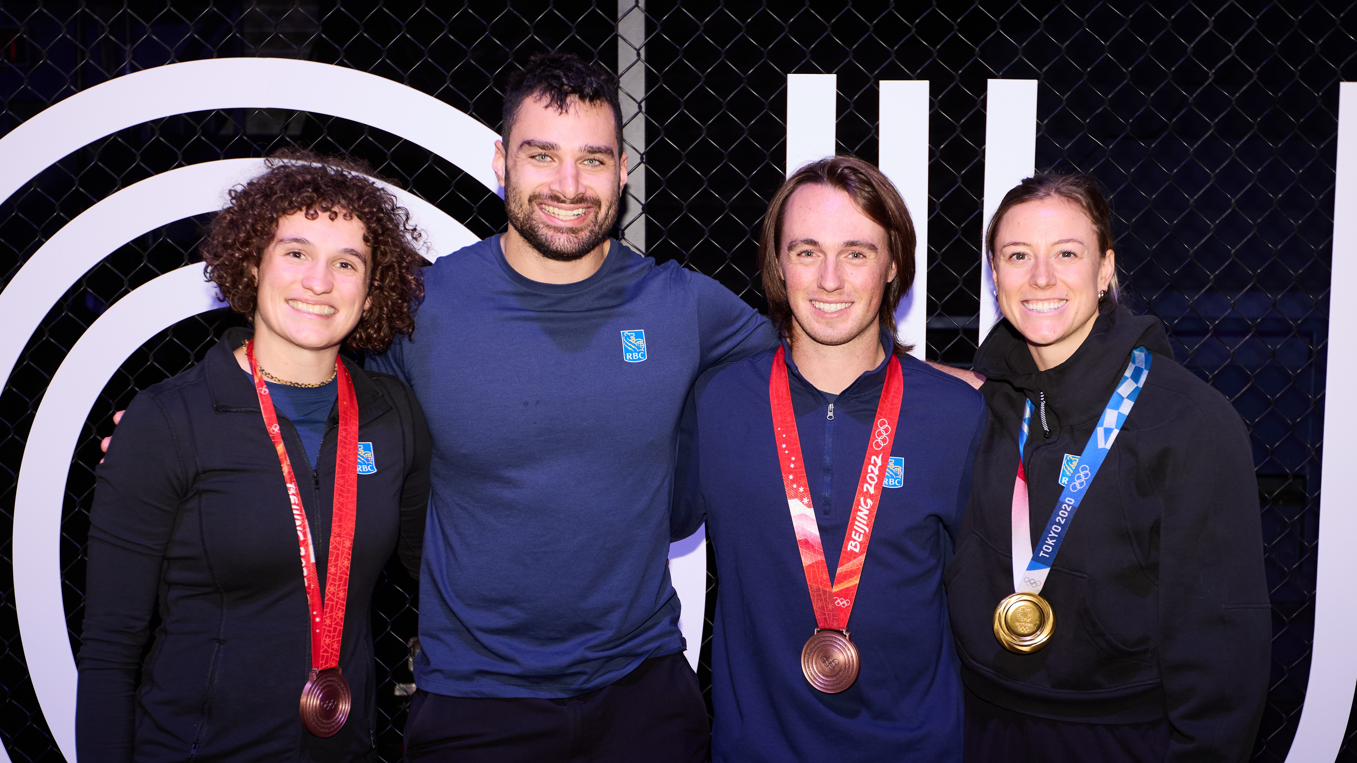 RBC Olympians posing together, with three of them wearing their medals.