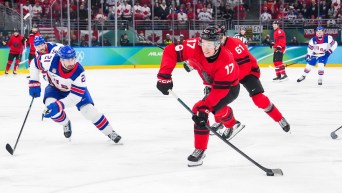 Macklin Celebrini shoots the puck