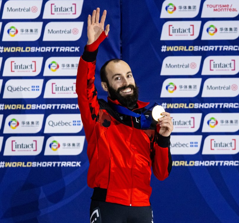 Steven Dubois wears gold medal around neck with red jacket