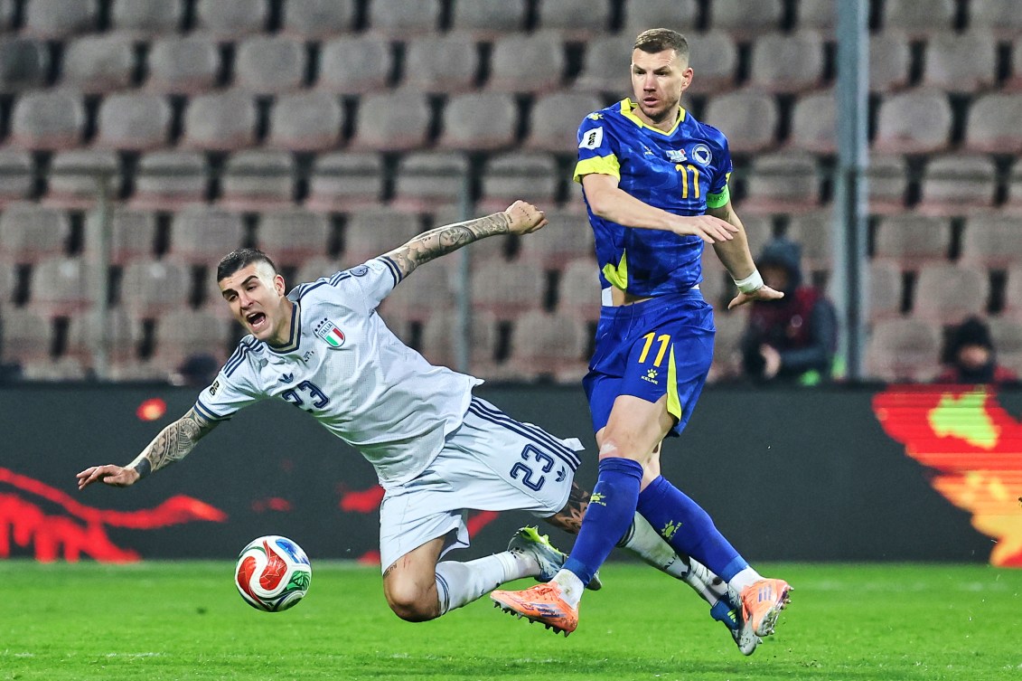 Italy's Gianluca Mancini, left, and Bosnia's Edin Dzeko battle for the ball 