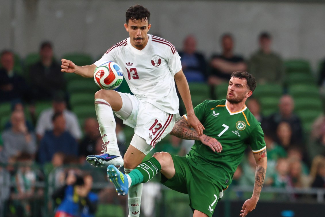 Qatar's Ayoub Al-Oui, left, challenges for the ball with Ireland's Troy Parrott