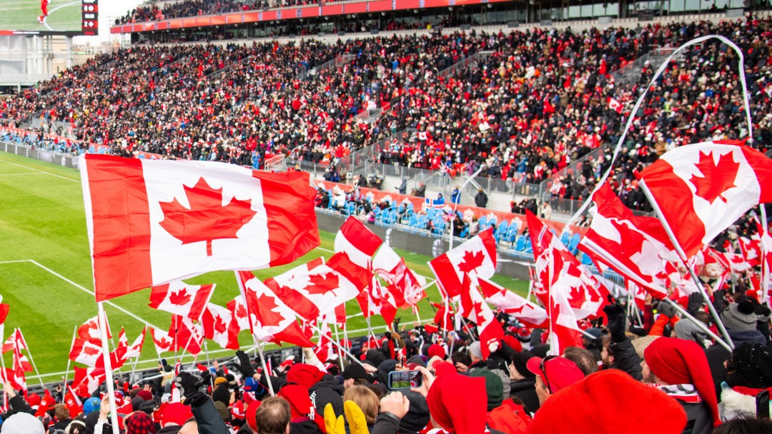 Fans wave Canadian flags at a match in Toronto