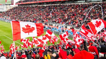 Fans wave Canadian flags at a match in Toronto