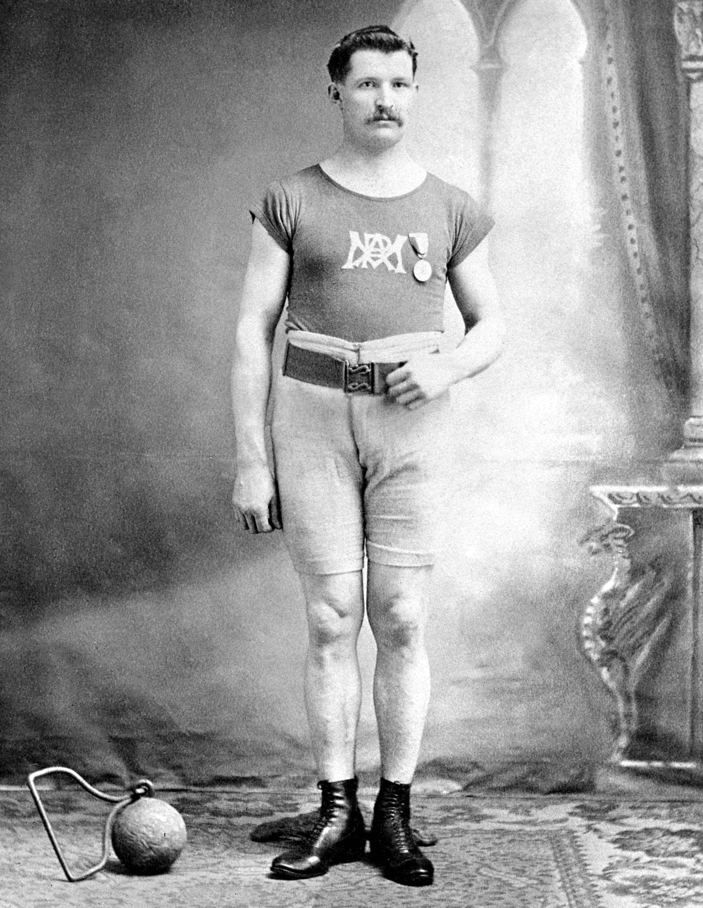 Le Canadien Etienne Desmarteau prend la pose avec sa médaille d'or remportée au lancer du poids 56 kg lors des Jeux de Saint-Louis en 1904. (CP Photo/COC)