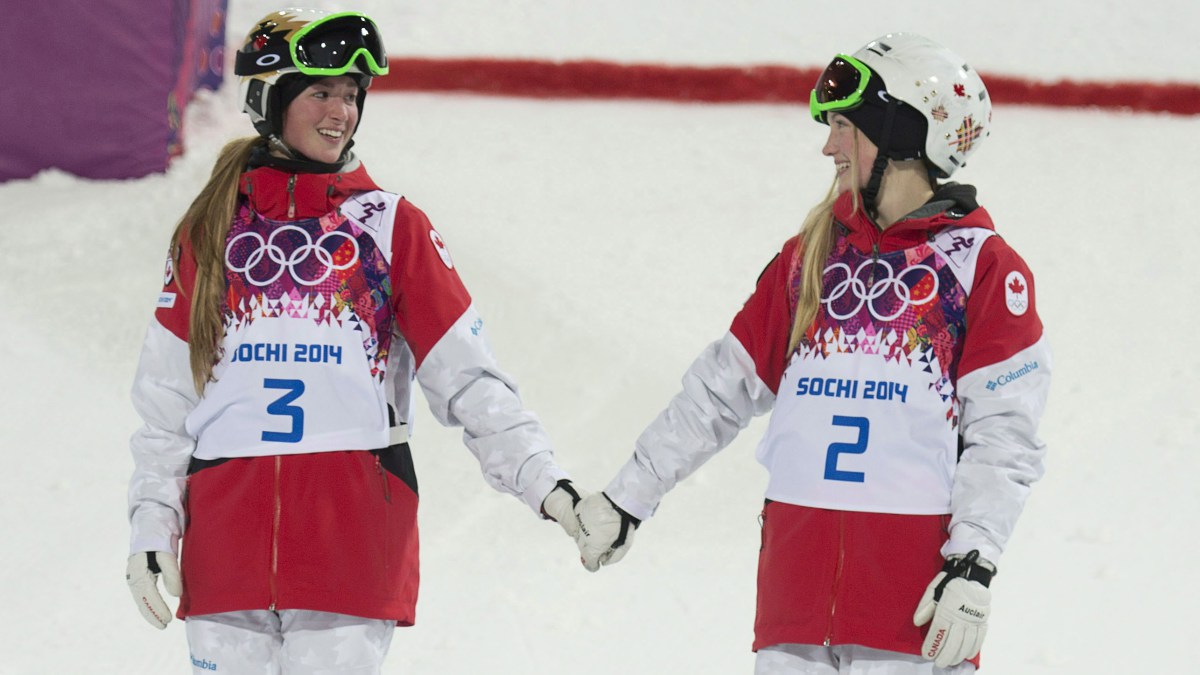 Justine (gauche) et Chloé Dufour-Lapointe se tiennent la main sur le podium après avoir remporté respectivement l'or et l'argent aux Jeux olympiques de Sotchi, le 8 février 2014.