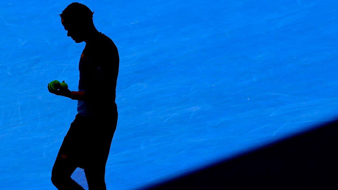 Dans l'ombre du soleil d’après-midi, Raonic s’apprête à servir contre Viktor Troicki au troisième tour des Internationaux d’Australie le 23 janvier 2016.