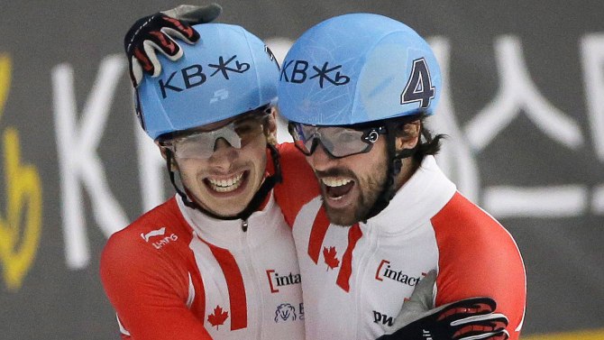 Samuel Girard (gauche) et Charles Hamelin célèbrent leurs médailles d'argent et d'or au 1000 m lors des Mondiaux de courte piste à Séoul, le 13 mars 2016.