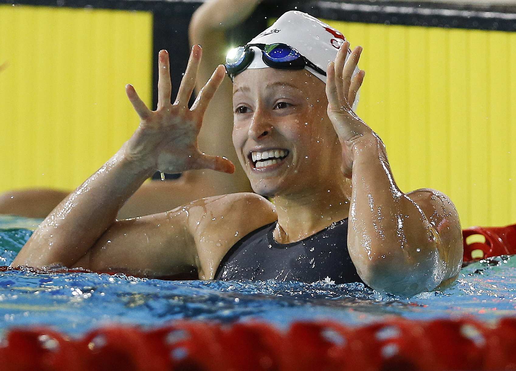 Katerine Savard of Canada celebrates winning gold in the Women's 100m Butterfly final at the Tollcross International Swimming Centre during the Commonwealth Games 2014 in Glasgow, Scotland, Friday July 25, 2014. (AP Photo/Kirsty Wigglesworth)