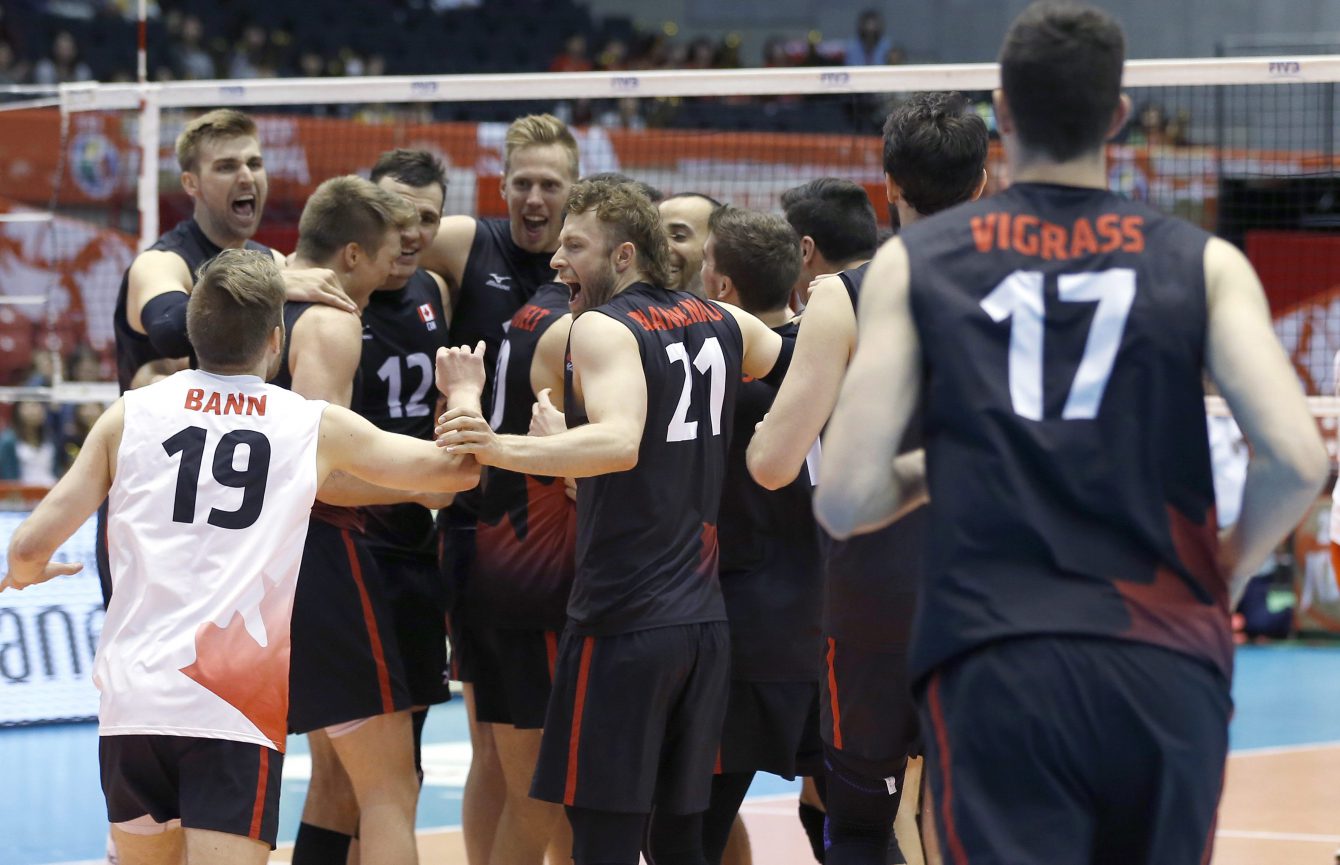Canada's volleyball team members celebrate after a win over China during their Men's Volleyball World Olympic qualification tournament match in Tokyo, Sunday, June 5, 2016. (AP Photo/Shizuo Kambayashi)