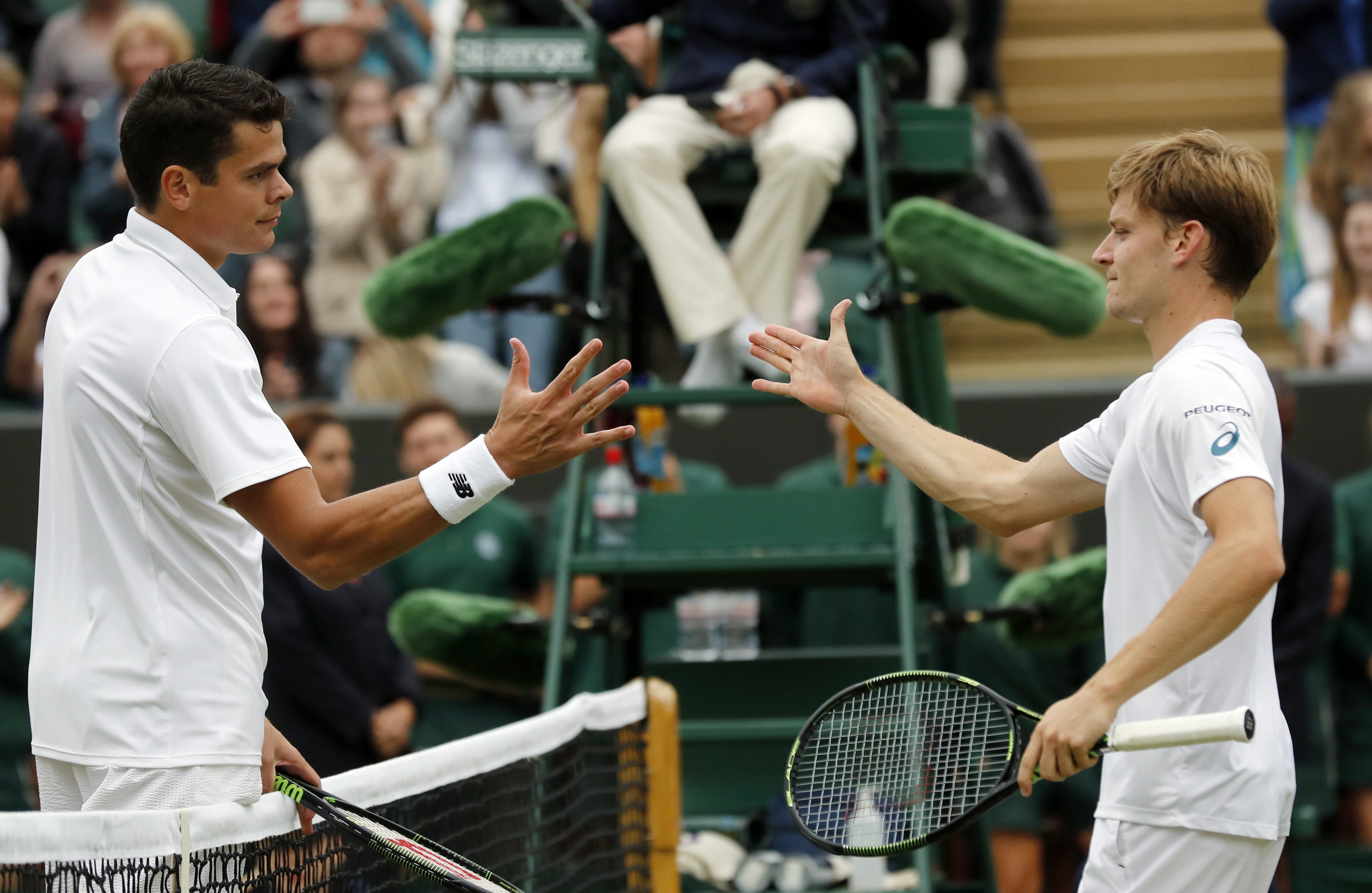 Milos Raonic of Canada, left, shakes hands with David Goffin of Belgium after beating him in their men's singles match on day eight of the Wimbledon Tennis Championships in London, Monday, July 4, 2016. (AP Photo/Ben Curtis)