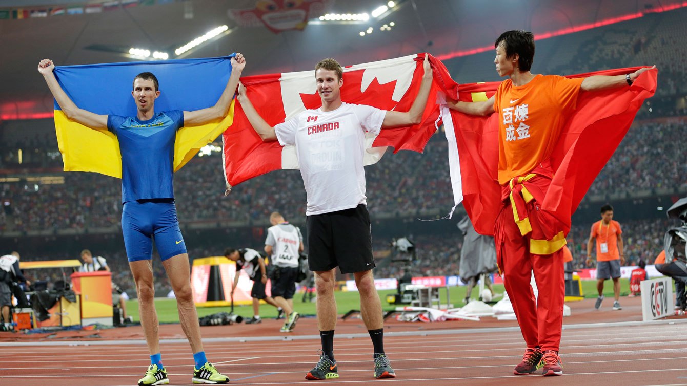 Derek Drouin (centre) entouré de Bohdan Bondarenko (gauche) et Guowei Zhang lors de la cérémonie des médailles aux Mondiaux d'Athlétisme le 30 août 2015 à Beijing, en Chine. 