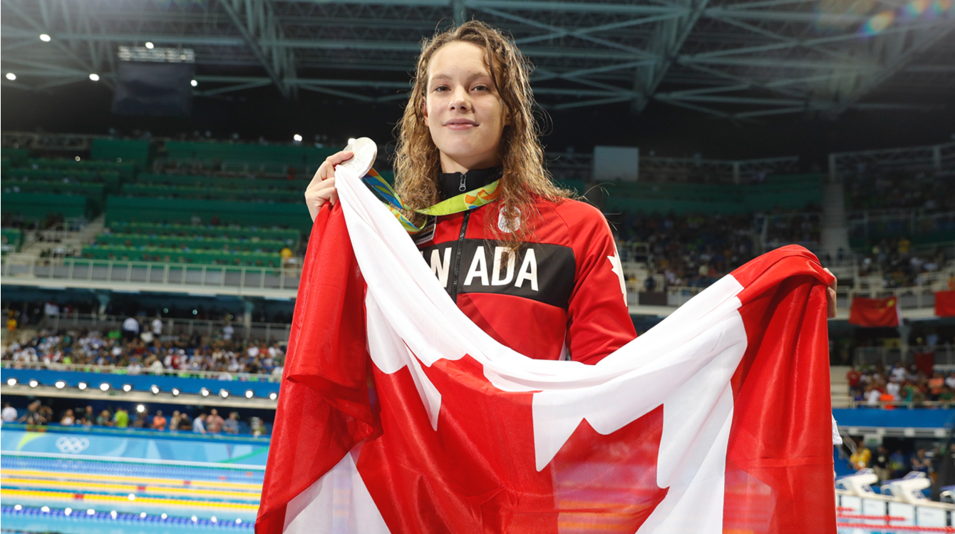 Penny Oleksiak avec le drapeau canadien lors de sa victoire au 100m papillon le 7 août 2016, à Rio 