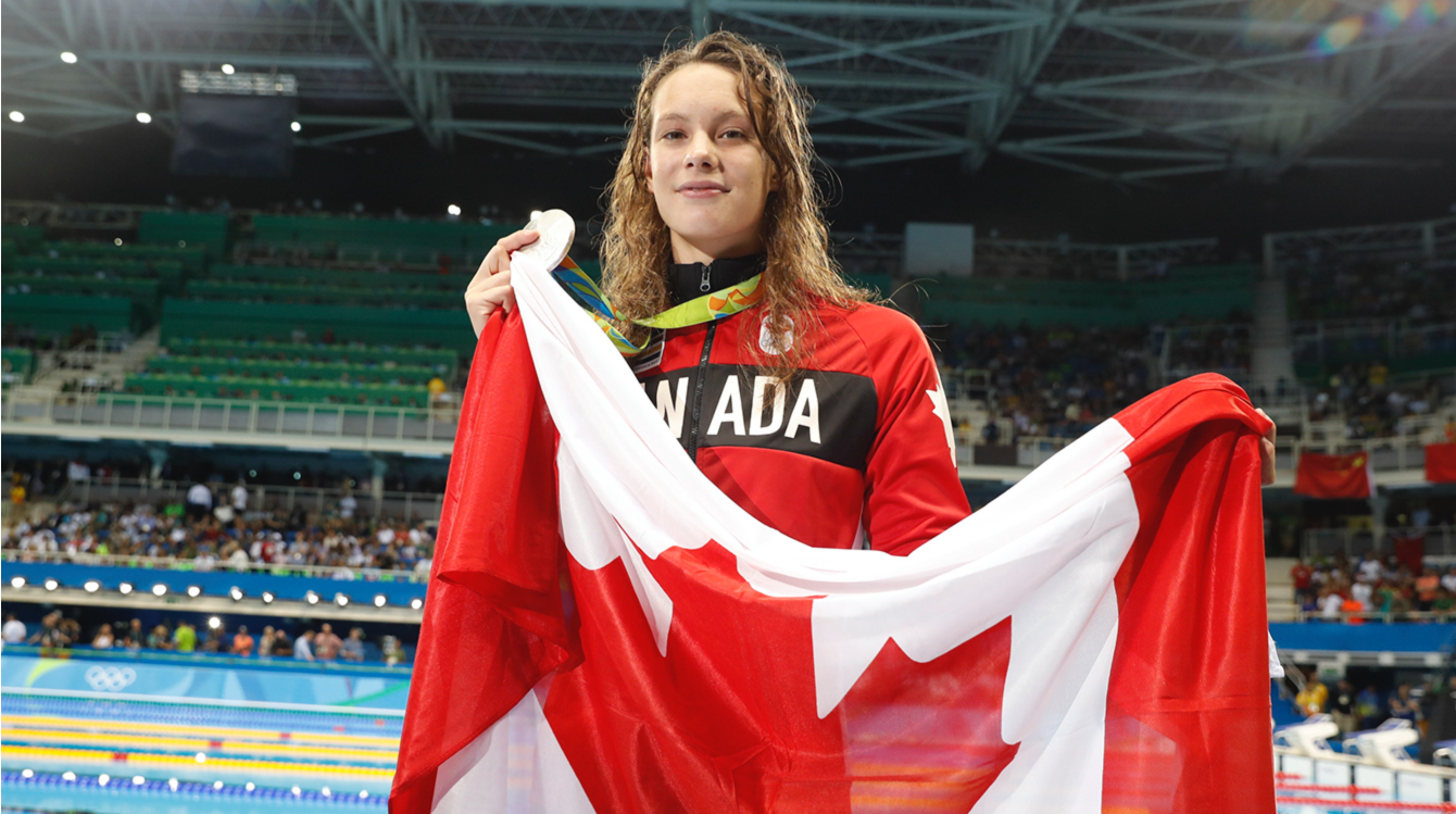 Penny Oleksiak avec le drapeau canadien lors de sa victoire au 100m papillon le 7 août 2016, à Rio