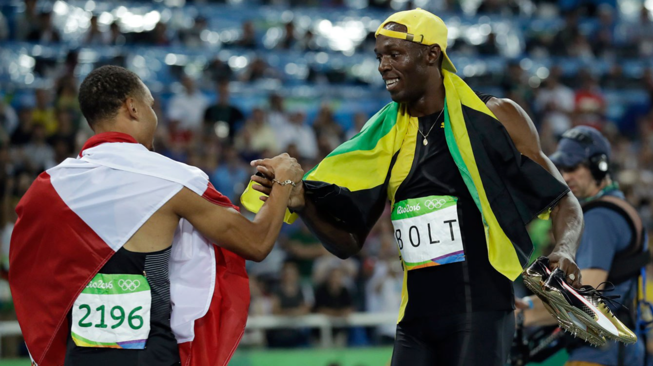 Usain Bolt (gauche) and Andre De Grasse après leur victoire au 100m des Jeux de Rio le 14 aout 2016.