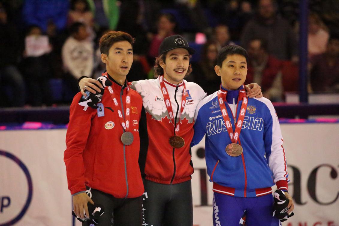 Dajing Wu de la Chine, Samuel Girard du Canada et Victor An de la Russie lors de la remise des médailles de l'épreuve du 500 m à la Coupe du monde de Calgary, le 5 novembre 2016. (Photo COC/Steve Boudreau)