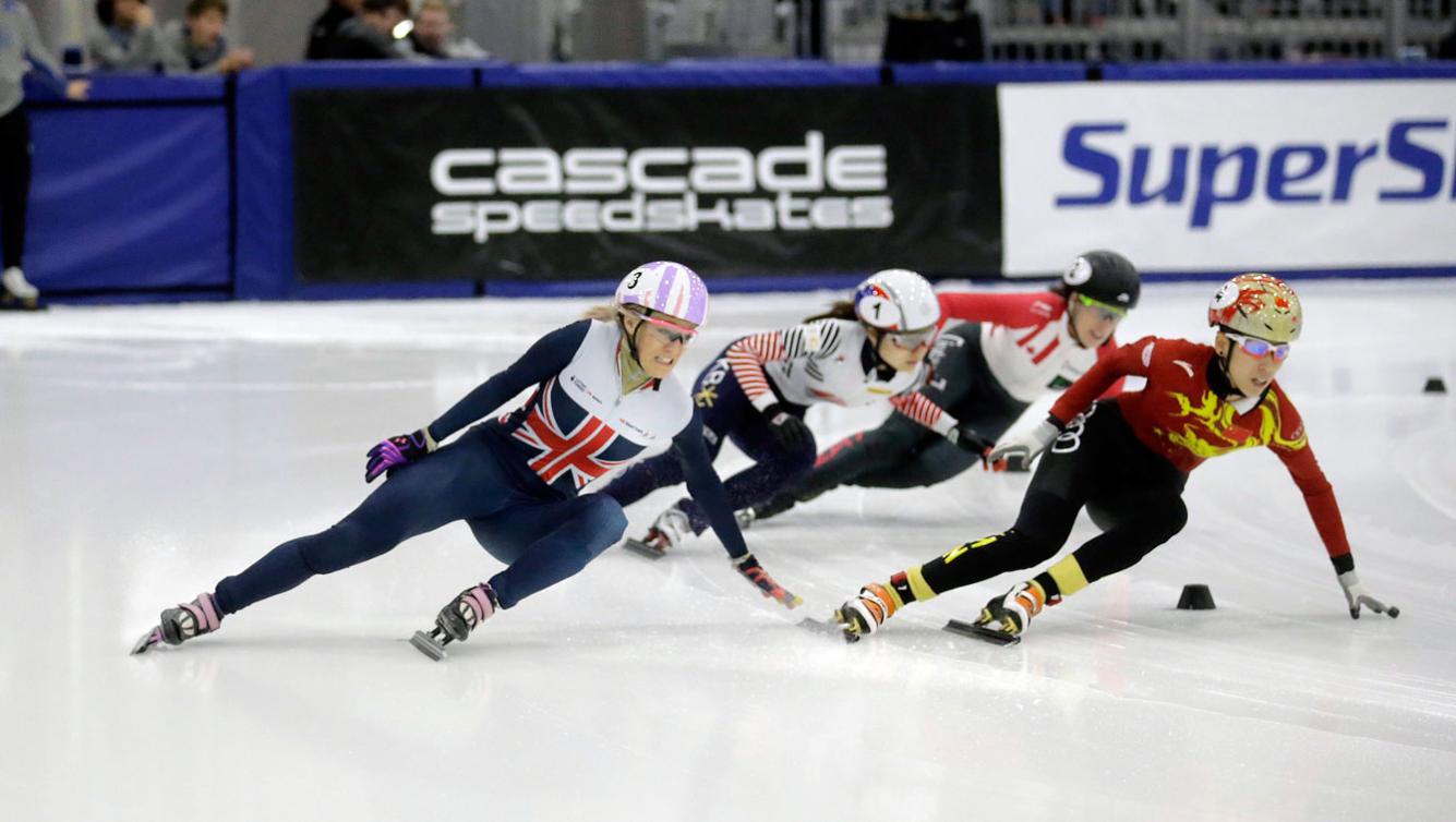 Elise Christie de la Grande-Bretagne (à gauche) chute et ouvre une porte à Marianne St-Gelais (à l'arrière) qui s'emparera de la tête du 500 m à la Coupe du monde de Salt Lake City, le 13 novembre 2016. (AP Photo/Rick Bowmer)