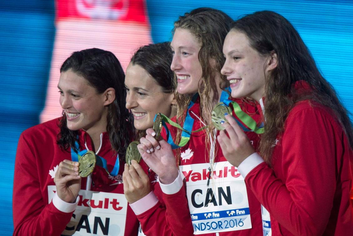Michelle Williams, Sandrine Mainville,Taylor Ruck, et Penny Oleksiak célèbrent leur médaille d'or au relais 4x50 m style libre aux Mondiaux sur 25 m de Windsor, le 11 décembre 2016. THE CANADIAN PRESS/Paul Chiasson