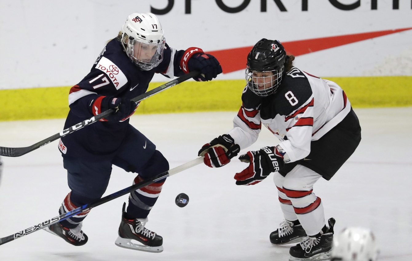 L'Américaine Jocelyne Lamoureux-Davidson (17) et la Canadienne Laura Fortino (8) se disputent la rondelle en deuxième période du match pour la médaille d'or du Mondial de hockey féminin à Plymouth, au Michigan, le 7 avril 2017. (AP Photo/Carlos Osorio)