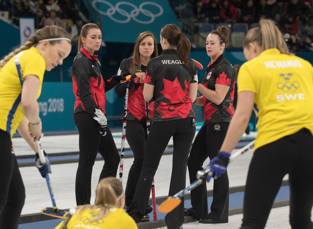 Équipe Canada, de gauche à droite : Emma Miskew, Rachel Homan, Lisa Weagle et Joanne Courtney discutent entre deux manches pendant le tournoi à la ronde, lors du match contre la Suède aux Jeux olympiques de PyeongChang, le 15 février 2018. Photo COC/Jason Ransom