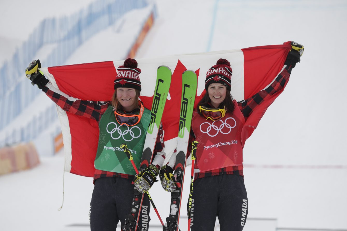 Kelsey Serwa et Brittany Phelan prennent la pause avec le drapeau canadien après avoir remporté l'or et l'argent respectivement à l'épreuve de ski cross féminin des Jeux olympiques de PyeongChang, en Corée du Sud, le 23 février 2018.