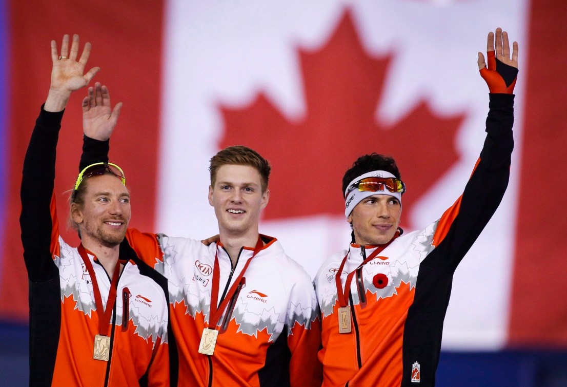 Ted-Jan Bloemen, à gauche, et ses coéquipiers Benjamin Donnelly et Jordan Belchos célèbrent leur médaille d'or après l'épreuve de poursuite par équipes à la Coupe du monde de l'ISU à Calgary, le 14 novembre 2015. LA PRESSE CANADIENNE/Jeff McIntosh