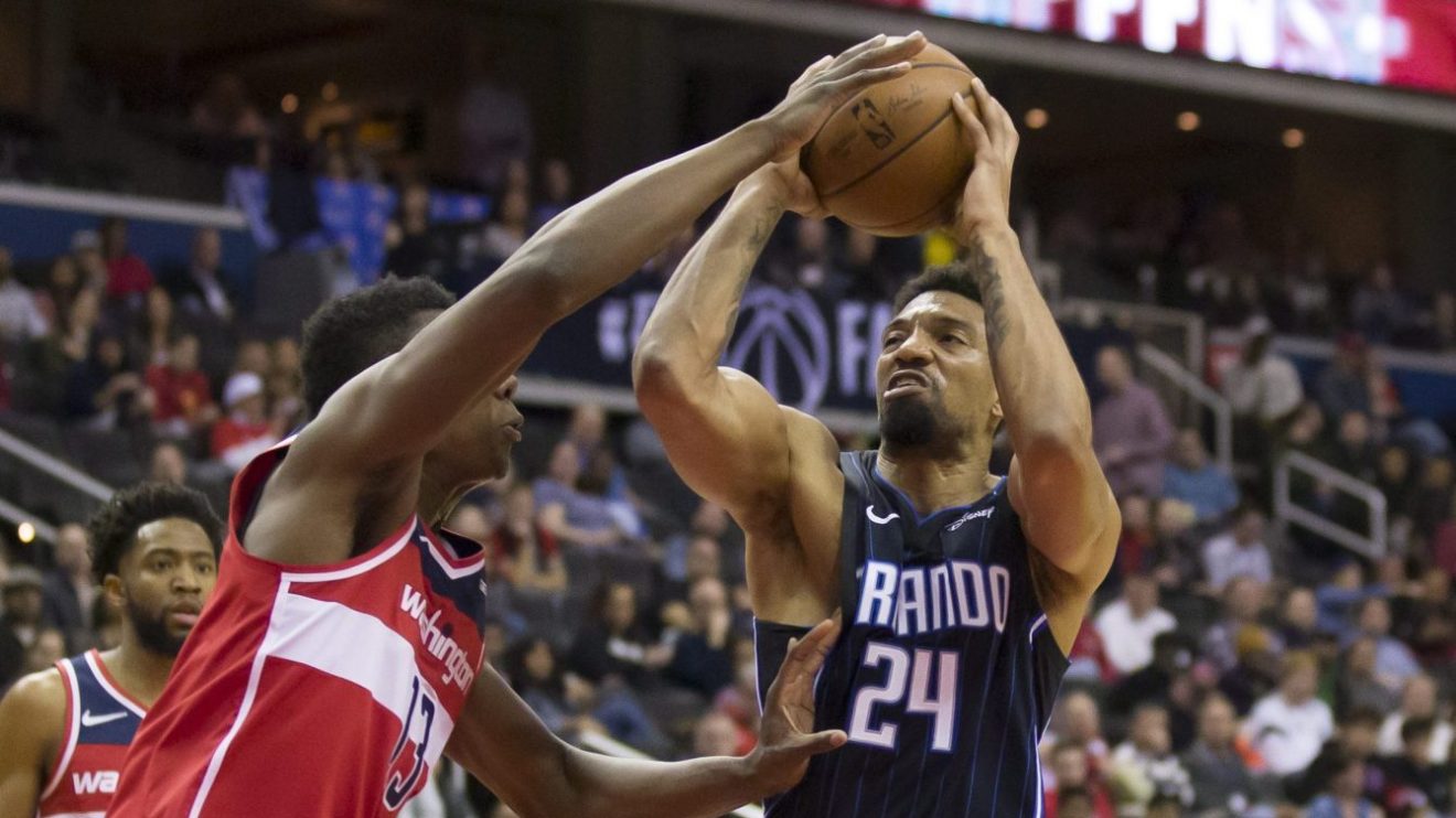 Le joueur de centre du Magic d'Orlando est sur le point de lancer le ballon devant un joueur des Wizards lors d'un match de la NBA à Washington.