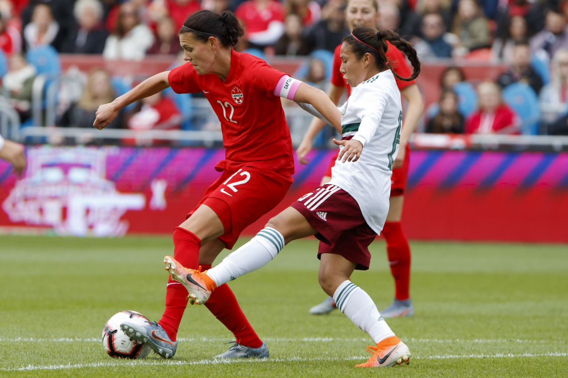 Deux joueuses de soccer luttent pour le ballon.