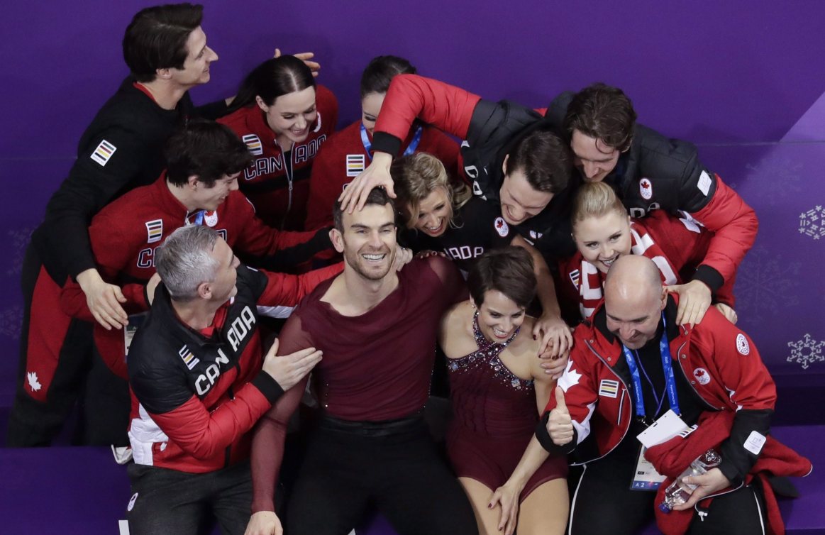 Meagan Duhamel et Eric Radford célèbrent avec leurs coéquipiers après avoir conclu leur programme à l'épreuve par équipe aux Jeux olympiques de PyeongChang