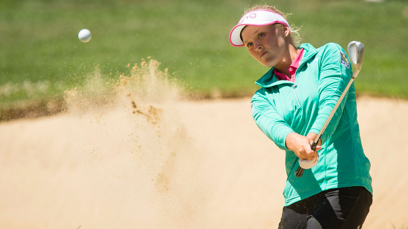 Une golfeuse dans une trappe de sable