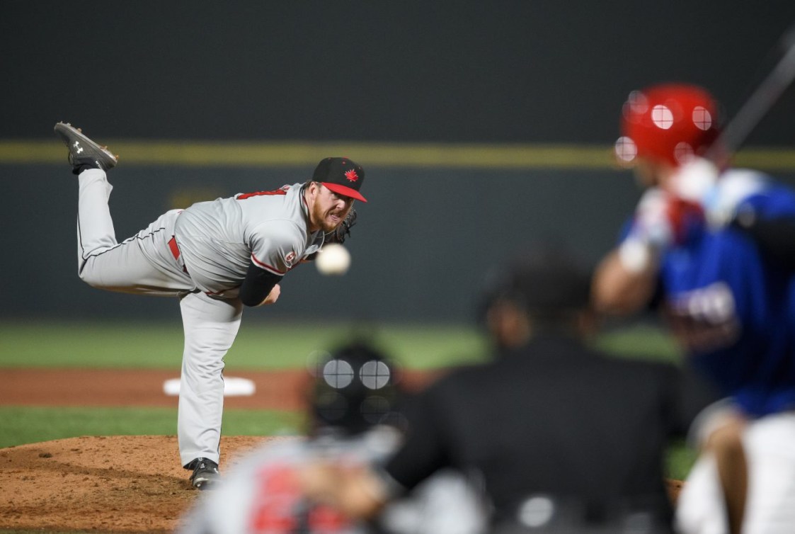 Un joueur de baseball lance une balle vers le batteur